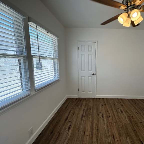 a room with a ceiling fan and a door.