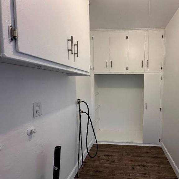 a kitchen with white cabinets and a wooden floor.