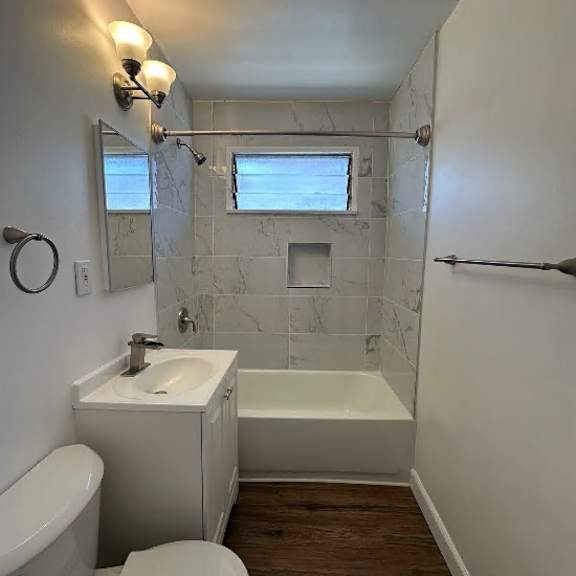 a white toilet sits next to a white sink in a bathroom.