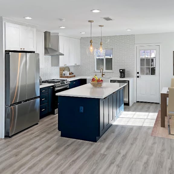 a modern kitchen with a large island and stainless steel appliances.