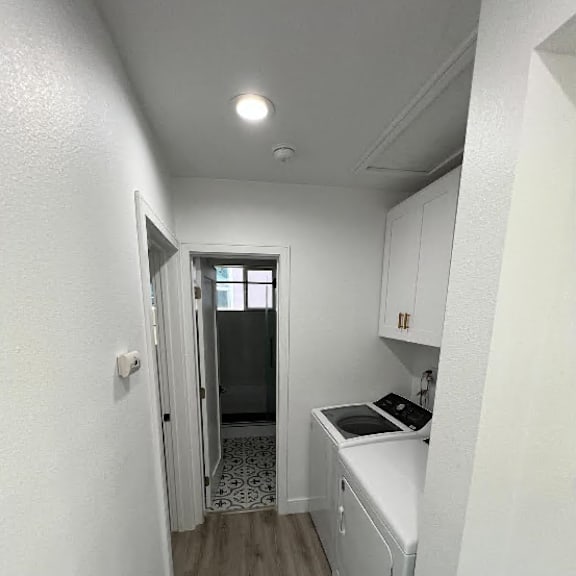 a small kitchen with white cabinets and a black stove top oven.