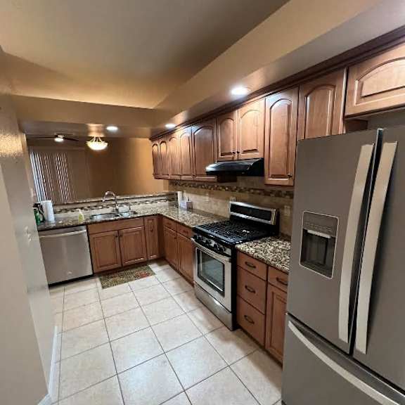 a kitchen with a refrigerator, stove, and microwave.