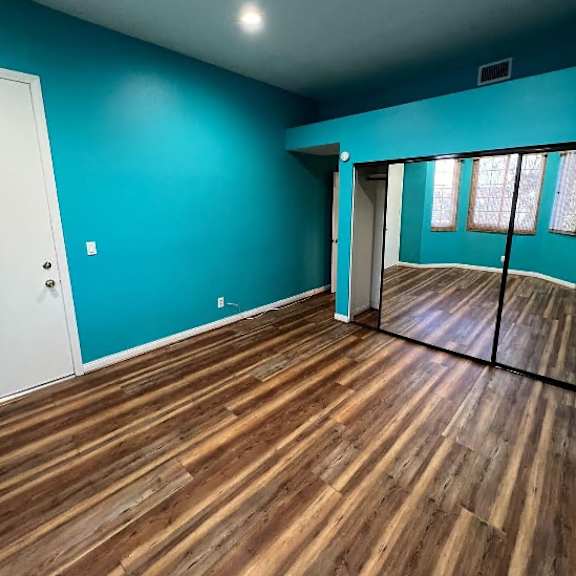 a room with wooden flooring and a white door.