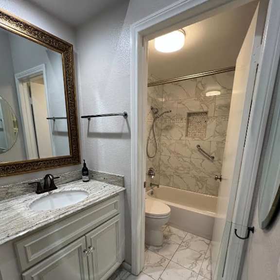 a bathroom with a marble tile floor and a white sink.