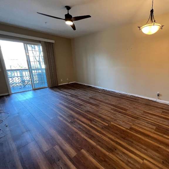 a room with wooden flooring and a ceiling fan.