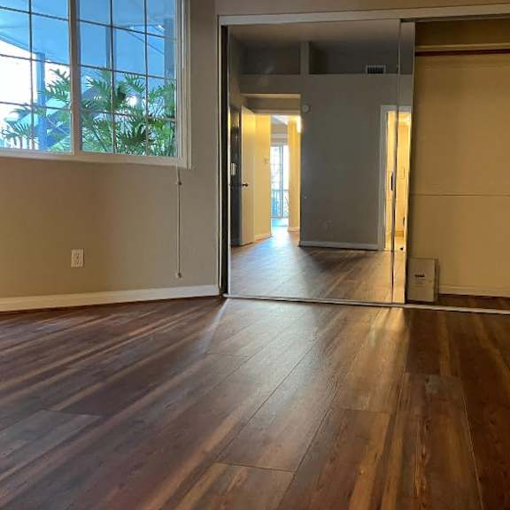 a room with wooden floors and a large window.
