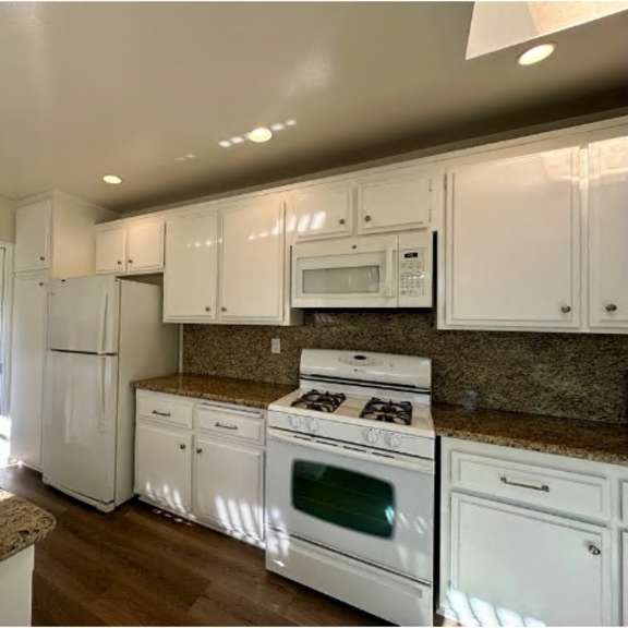 a kitchen with white appliances and cabinets.