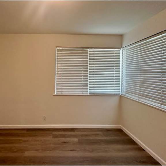 a room with a window covered by white blinds.