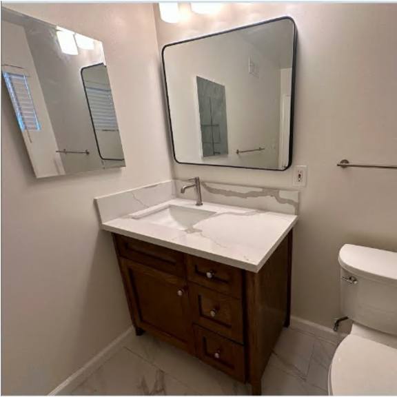 a white toilet sits next to a sink in a bathroom.