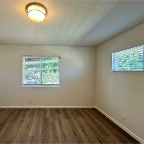 a room with a window and wooden flooring.