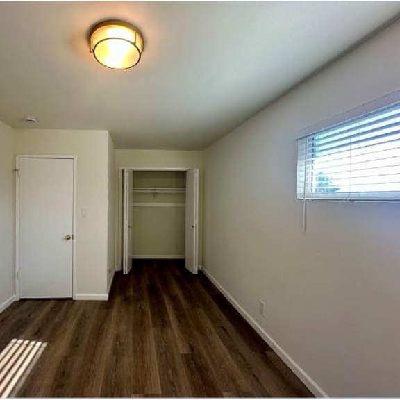 a room with a white door and a window with blinds.