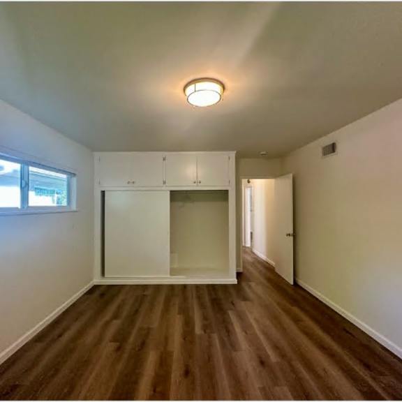 a room with wooden floors and a white cabinet.