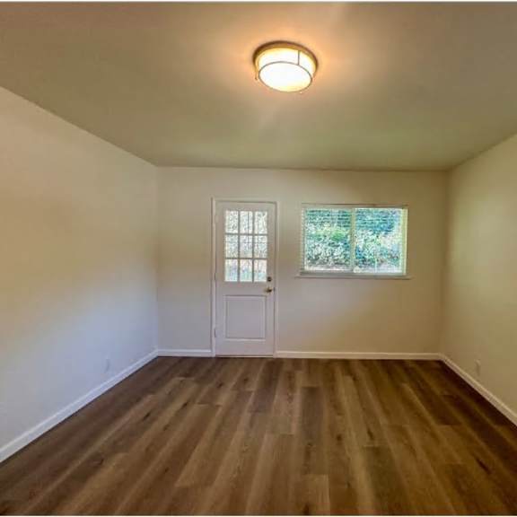 a room with wooden floors and a white door.