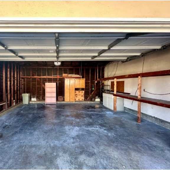 a spacious garage with a concrete floor and walls under construction.