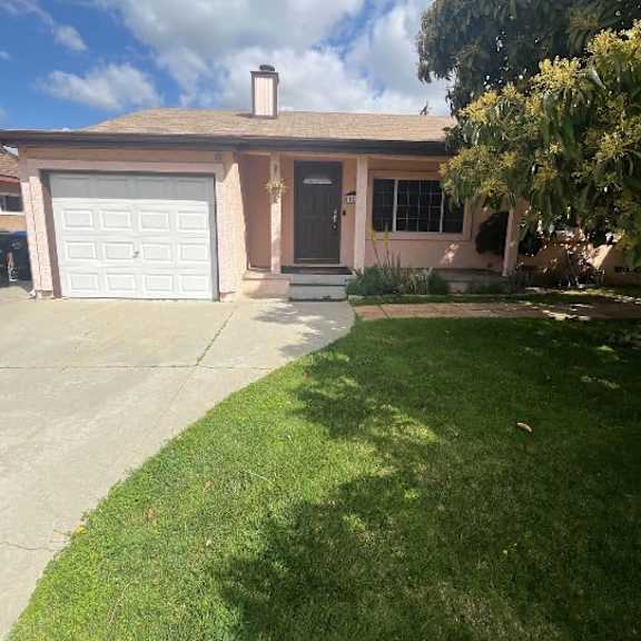 a house with a white garage door and a brown roof.