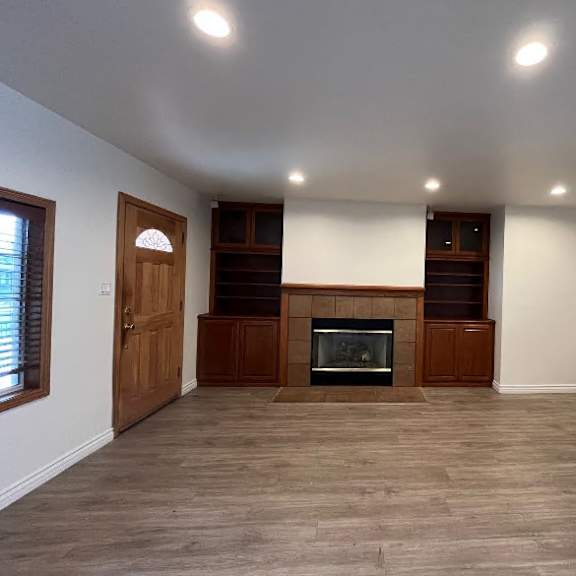 a room with a fireplace and wooden floors.
