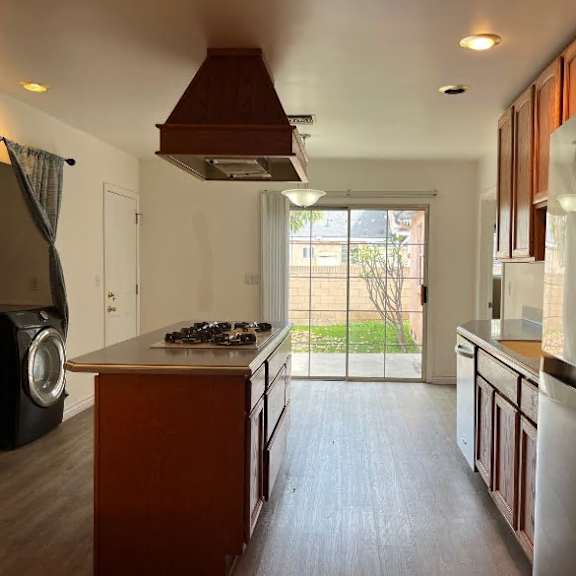 a modern kitchen with a large island and wooden cabinets.