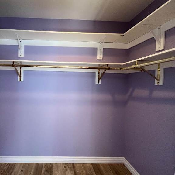 a room with purple walls and a white ceiling with a wooden floor.