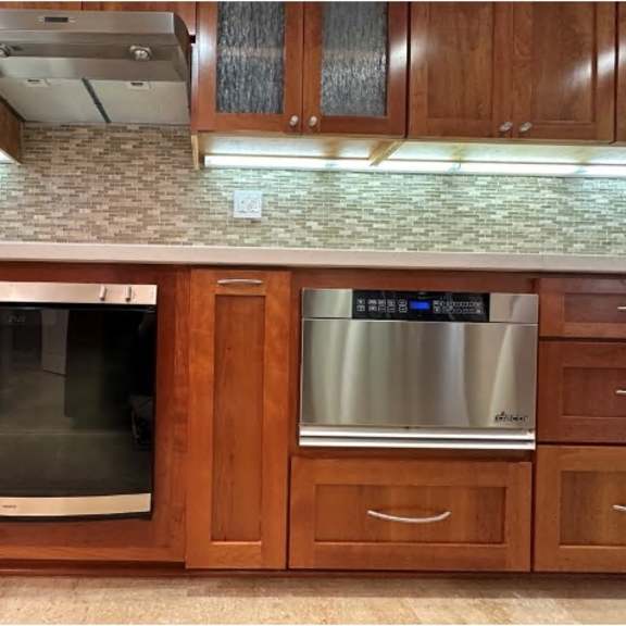 a modern kitchen with wooden cabinets and a stainless steel dishwasher.