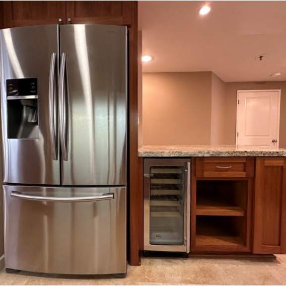 a stainless steel refrigerator with its door open in a kitchen.
