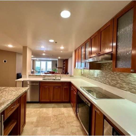 a kitchen with granite countertops and wooden cabinets.