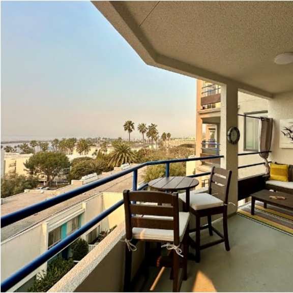 a balcony with a table and chairs overlooking a street.