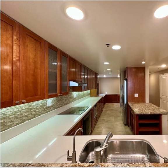 a kitchen with brown cabinets and a marble countertop.