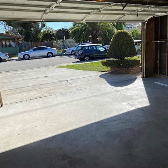 a parking lot with cars and a green bush in the middle.