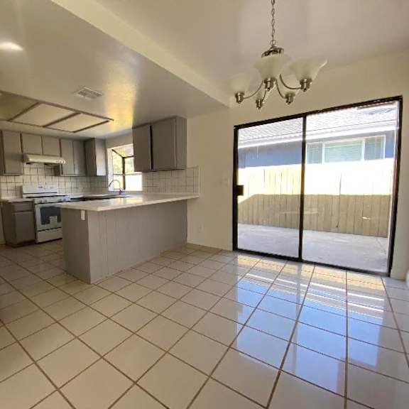 a kitchen with a refrigerator, sink, and stove.