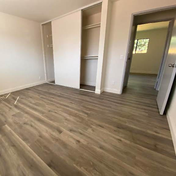 a room with wooden flooring and white walls.