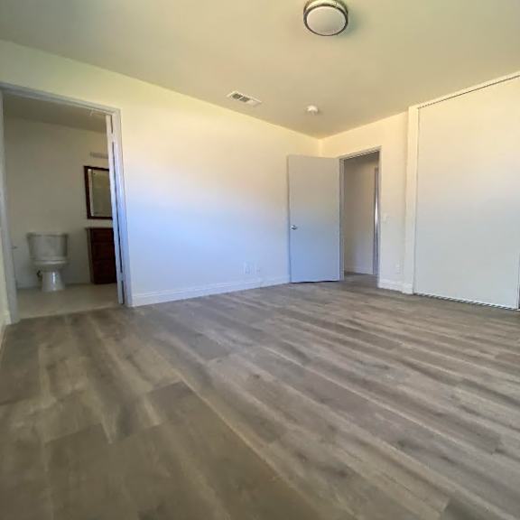 a room with wooden flooring and white walls.
