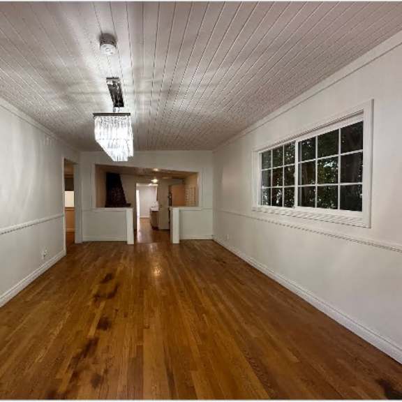 a long hallway with wooden floors and white walls.