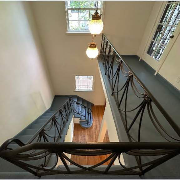 a staircase with a metal railing and a window in the background.