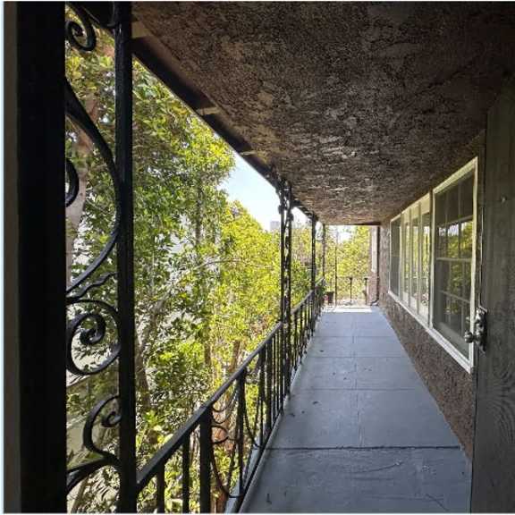 a balcony with a metal railing and a view of trees.