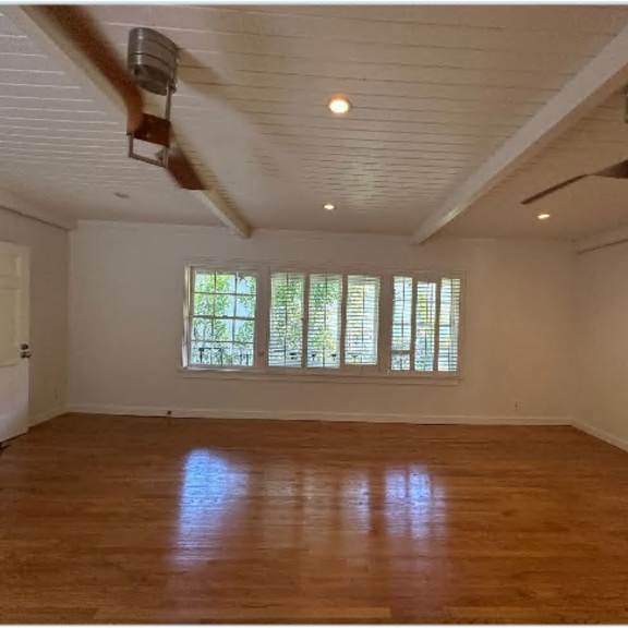 a room with wooden floors and a ceiling fan.