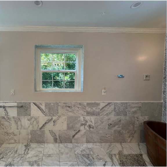 a bathroom with a marble floor and a window.
