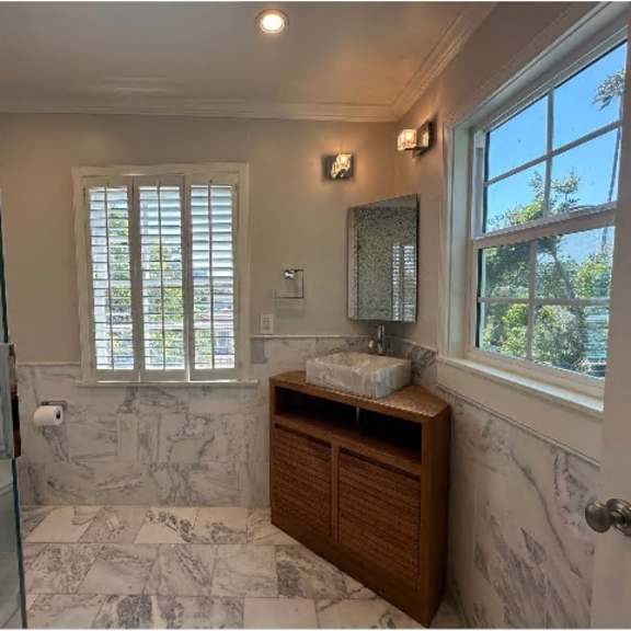 a bathroom with a marble floor and a wooden cabinet.