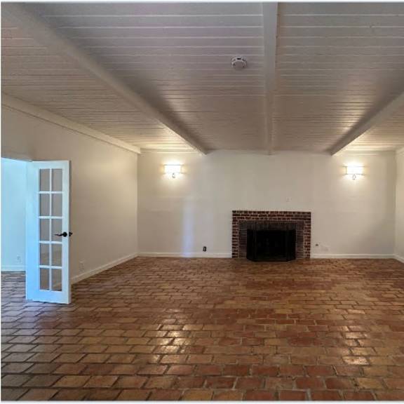 a room with a fireplace and a door on the left.
