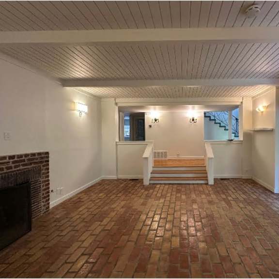 a room with a brick floor and a fireplace.