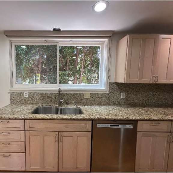 a kitchen with a granite countertop and wooden cabinets.