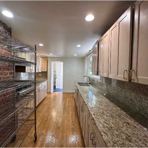 a kitchen with wooden floors and granite countertops.