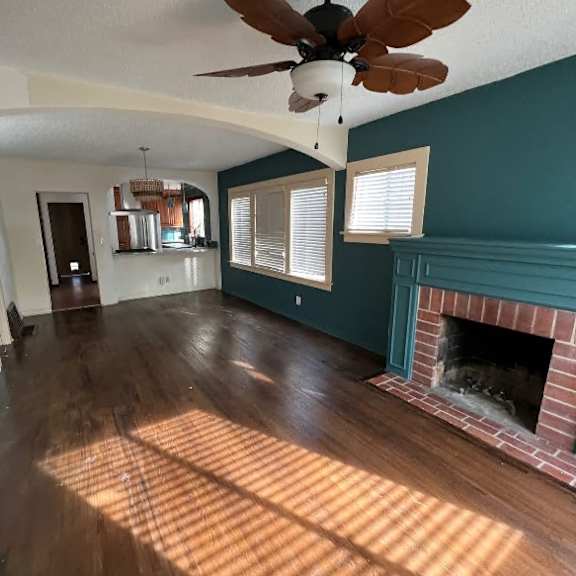 a room with a fireplace and a ceiling fan.