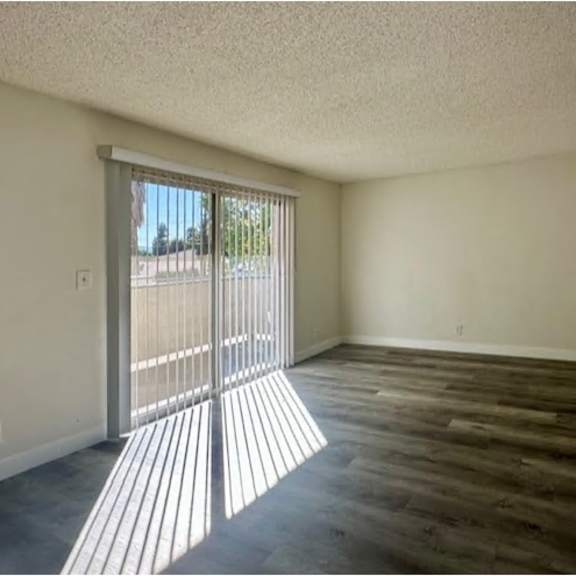 a room with wooden flooring and a sliding glass door.