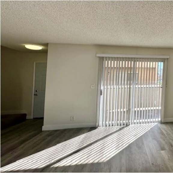 a room with a sliding door and wooden flooring.