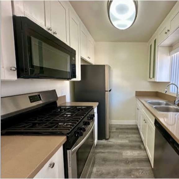 a kitchen with black appliances and white cabinets.