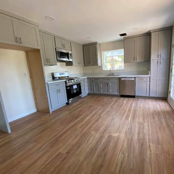 a kitchen with wooden floors and white walls.