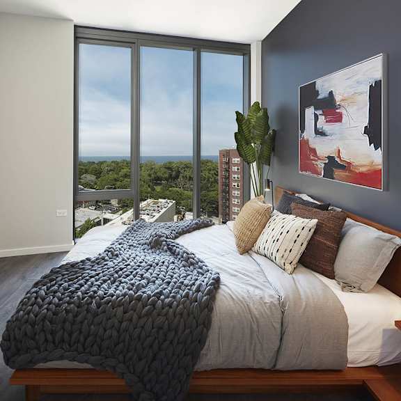 a bedroom with a large bed and a view of the city.
