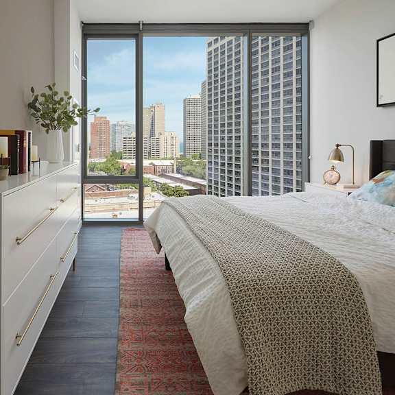a bedroom with a large bed and a view of the city.