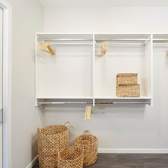 a white closet with a shelf and baskets.