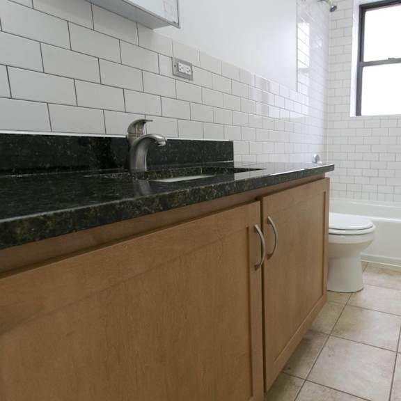 a bathroom with a black granite countertop and a white toilet.